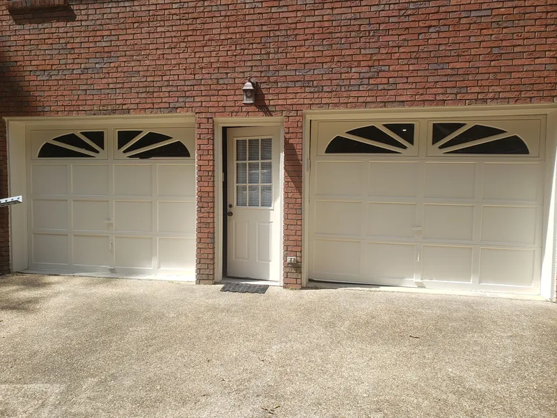 Two garage doors with sunburst arched windows