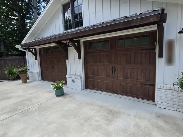 The same farmhouse garage from the side, the doors under a dark wood awning