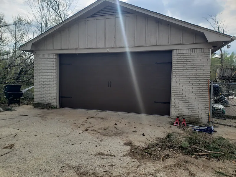 The same garage with a new dark brown door installed